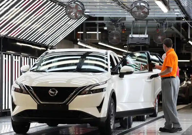 Ouvrier assemblant une Nissan sur une ligne de production automobile