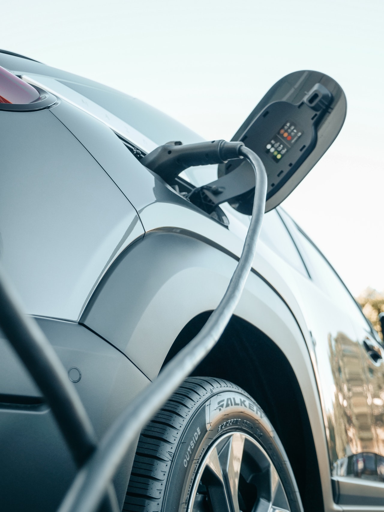 Câble branché sur la trappe de recharge d’une voiture électrique